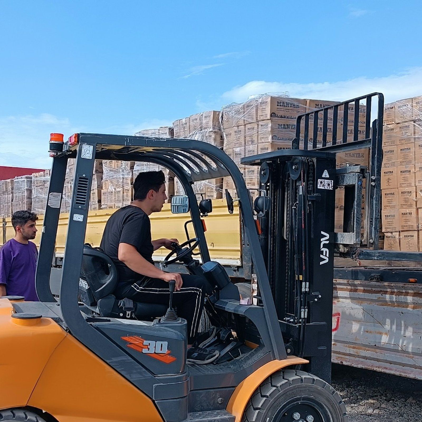 Forklift loading pallets onto a truck