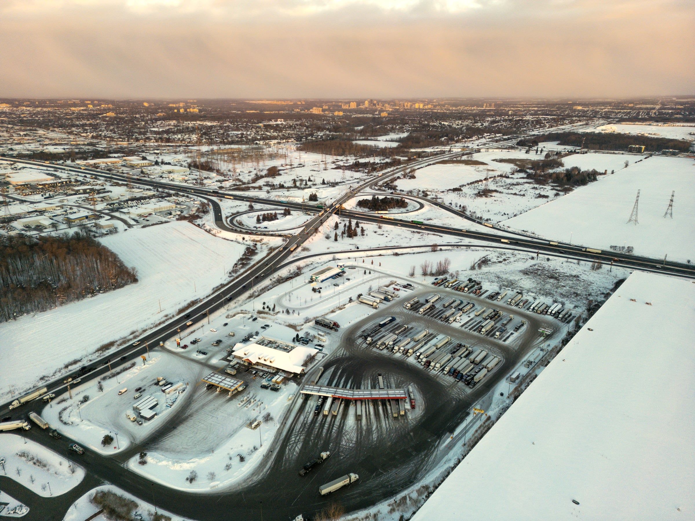 Snowy highway interchange at sunset, aerial view